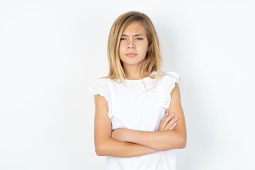 beautiful caucasian teen girl wearing white T-shirt over white wall Pointing down with fingers showing advertisement, surprised face and open mouth
