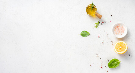 Various herbs and spices, oil in glass bowl and half of lemon on a white concrete background. Background for recipe, menu, text © Tatyana Sidyukova