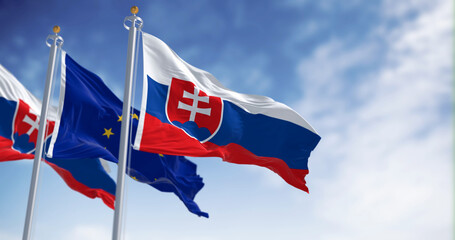 The flags of Slovakia and the European Union fluttering together on a clear day