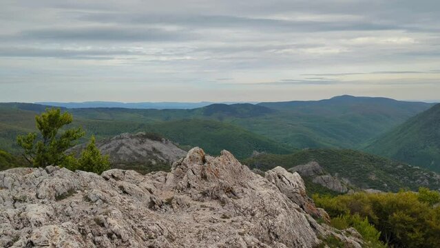 Panoramic view of the valley on top of the rocky ridge among the stones overlooking the beautiful valley. Outdoor and mountain hike background. Natural landscape in Bulgaria, Sliven