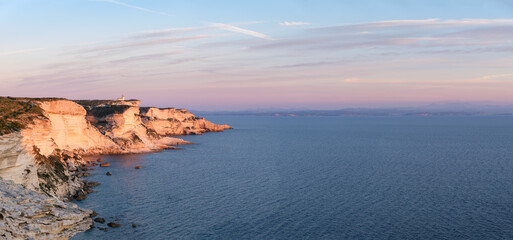 Panorama des falaises de Bonifacio en Corse du Sud au coucher du soleil. Vue sur les côtes de Sardaigne en arrière plan