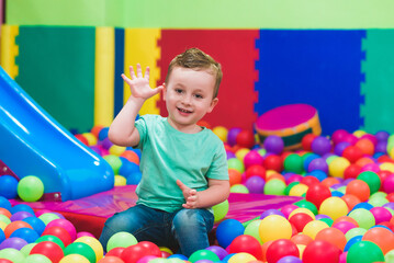 Child on the playground with colored plastic balls