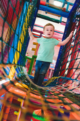 little boy playing inside a tunnel in the playground voting balls