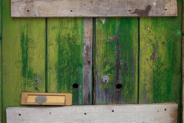 Green wooden boards, rough texture, door with lock