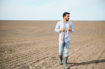 Young indian farmer at agriculture field. - obrazy, fototapety, plakaty
