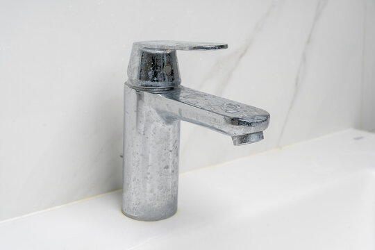 dirty water faucet covered in soap and limescale