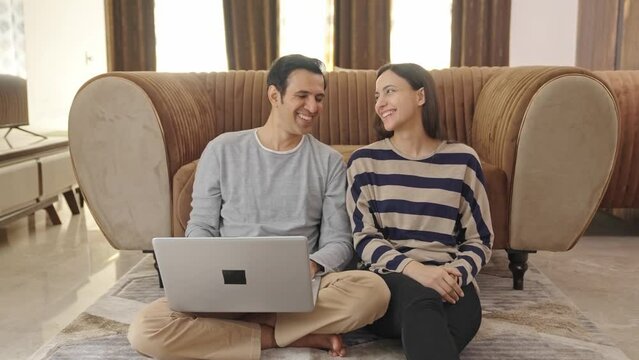 Indian couple planning something and typing on laptop