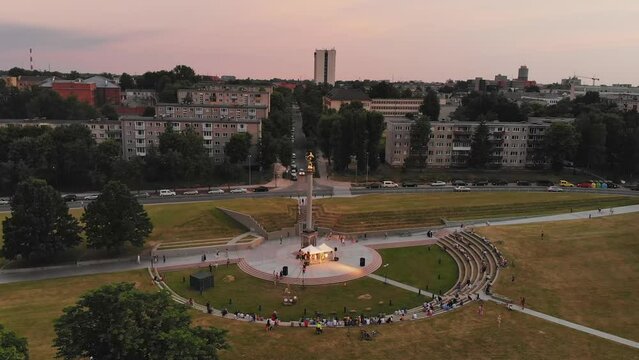 Aerial view St. Johns midsummer festival concert in city Siauliai with people sitting in sun clock listening live music. Siauliai. Lithuania