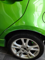 green car fender with scratched scuffs