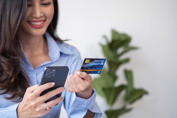 Beautiful Asian women using credit cards for shopping online with laptops and smartphones, online shopping portrait concept.