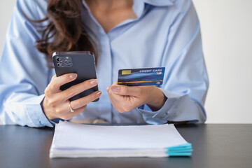 Beautiful Asian women using credit cards for shopping online with laptops and smartphones, online shopping portrait concept.