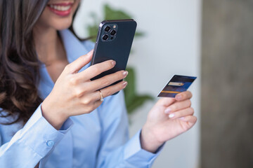 Beautiful Asian women using credit cards for shopping online with laptops and smartphones, online shopping portrait concept.