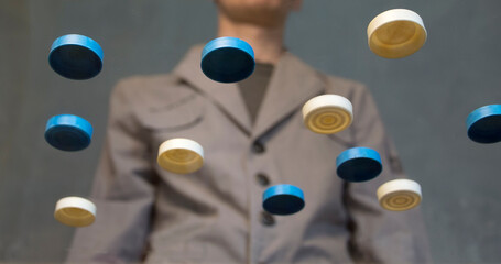 Checkers on a glass table and a young man in the background.