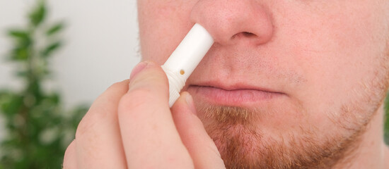 Adult man uses nasal stick inhaler to smell for relieve dizzy and faint symptoms. Concept health...