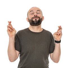 Portrait oh excited man with beard with fingers crossed, Concept of wishing for good luck or praying about something, isolated on white background. Bald forty year old guy posing in studio.