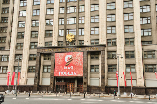 Russia Moscow 08.05.2023.Facade State Duma building with red poster May 9 is Victory Day.