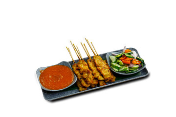Pork Satay on plate. Grilled pork served with peanut dipping sauce,toasted bread and sweet sour sauce decorated with cucumber,onion and chili. One of the best Thai street food.