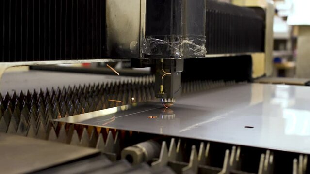 Automated CNC laser machine cuts stainless steel sheet. Laser cutting of metal
