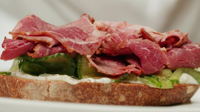 American pastrami sandwich in New York ham meet cuts. chef cooking Famous thick cut sous vide beef sandwich on restaurant cafe kitchen.