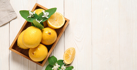 Wooden box with fresh lemons, flowers and leaves on white table. Banner for design - Powered by Adobe