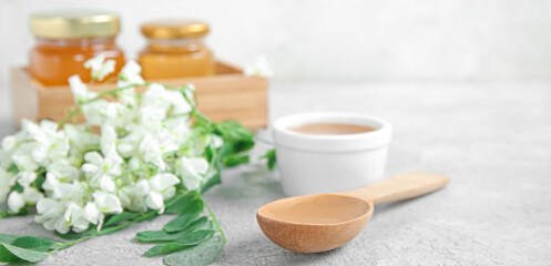 Composition with sweet acacia honey on light background, closeup