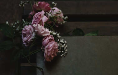natural background in dark  tone with graceful small pink roses and shallow white flowers of...