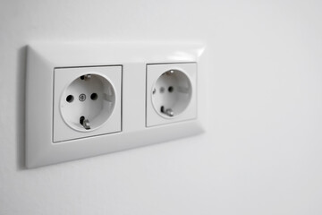 Electric sockets on white wall, closeup