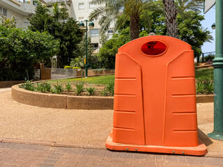 Orange garbage container on city street