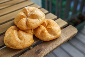 Kaiser rolls on wooden table, closeup