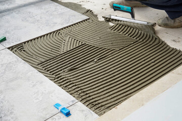 Close-up detail of floor tiles installation. Home improvement, renovation - ceramic tile floor...