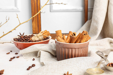 Fototapeta na wymiar Composition with cinnamon sticks and coffee beans on light background
