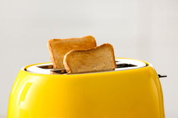 Modern toaster with crispy bread slices, closeup