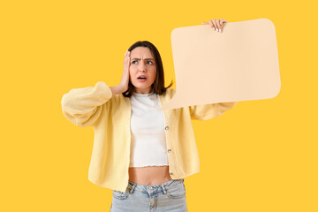Shocked young woman with blank speech bubble on yellow background