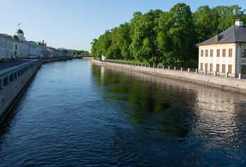 A two-story mansion in a summer garden on the banks of the river
