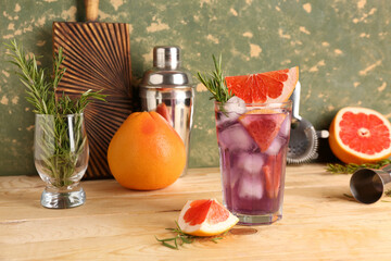 Glass of purple gin and tonic with grapefruits on wooden table
