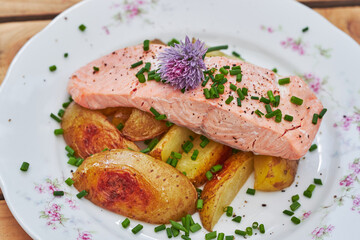 Close up picture of tasty poached or steamed wild salmon fillet served with baked new poptatoes and...