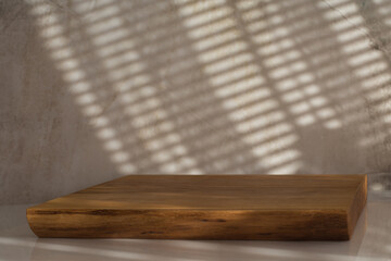 Drewniana deska na białym blacie, na teksturowej ścianie światło słoneczne, tło do...