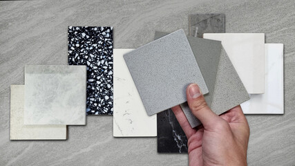 interior designer compaing set of grainy quartz samples with black marble, grey artificial stone, terrazzo tiles samples. countertop or tabletop furnishing material samples on travertine background. - obrazy, fototapety, plakaty