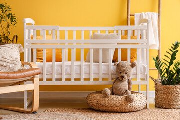 Interior of stylish bedroom with baby crib, armchair and ladder - obrazy, fototapety, plakaty