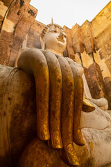 Giant statue of seated Buddha in mara mudra position, enveloped in an atmosphere of silence and mysticism, at Wat Si Chum temple, in the Sukhothai region, Thailand, Southeast Asia