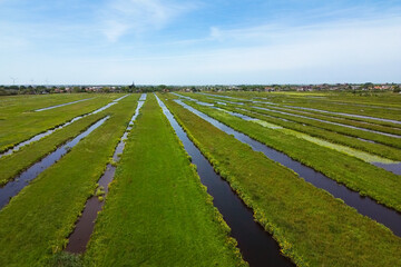 Stunning aerial view of the wide open Dutch polder landscape with parallel water filled ditches and...