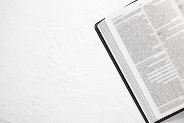 Open Holy Bible on white textured background