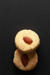 Two Almond Cookies on black background. Top-down view. Food Flat lay.