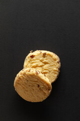Two whole wheat chip cookies on black background. Top-down view. Food Flat lay.