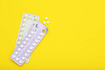 Oral contraceptive pills on yellow background