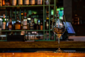 Realistic photo, close-up view of professional bartender in bar making cocktail in a tall glass, with ice and alcohol, male hands in picture
