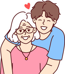 Noble guy teenager hugging elderly grandmother showing love and care for ancestors