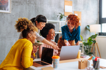 Multiracial young business women discussing project development in office