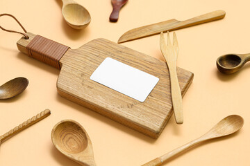 Composition with blank card and wooden cutlery on beige background, closeup