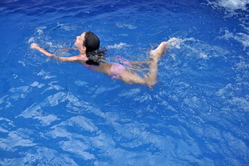 criança feliz brincando na piscina 